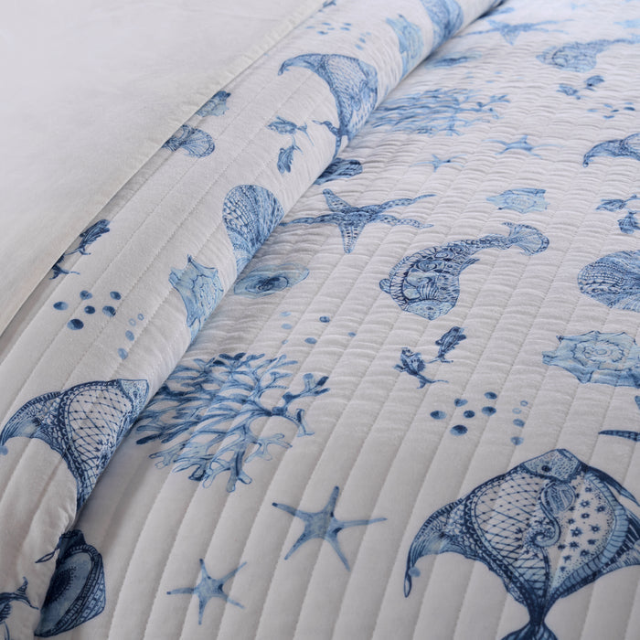 Quilt with blue sea-themed pattern on a white background