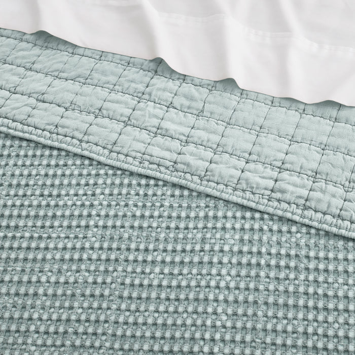 Close-up of a textured green fabric with a white background