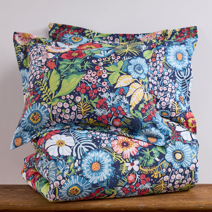 Floral patterned bedding set on a wooden surface with a neutral background