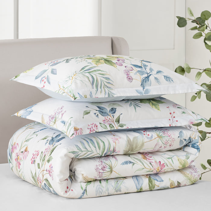 Seraphine Blooms Comforter Set featuring layered pillows and comforter with floral design in soft colors.