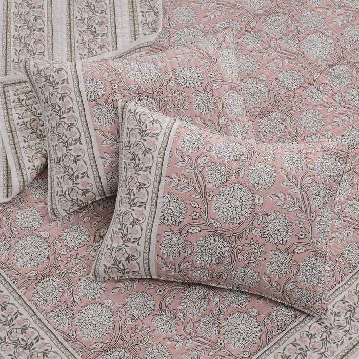 Floral patterned bedding set with pillows on a matching fabric background