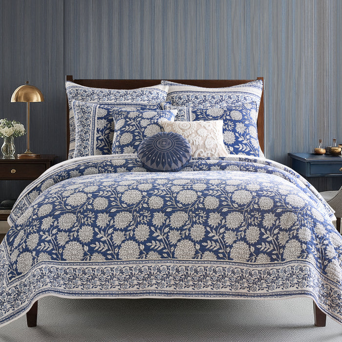 Blue and white floral patterned bedding set on a bed with matching pillows
