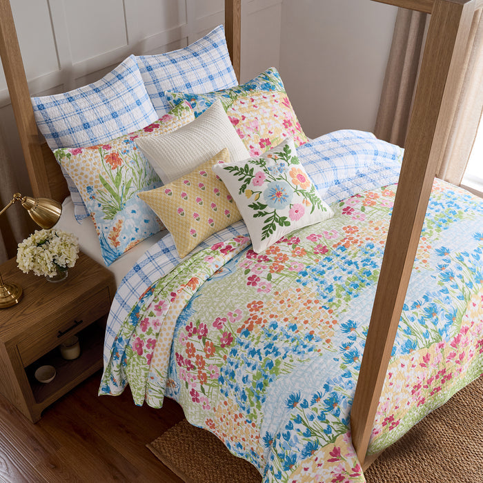 Bed with floral bedding and pillows in a bedroom setting