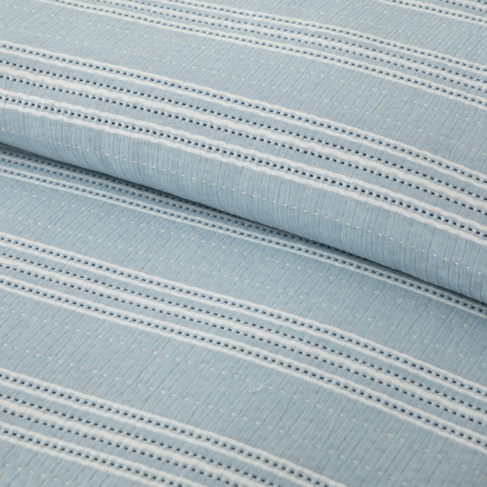Close-up of light blue fabric with white stripes and stitching