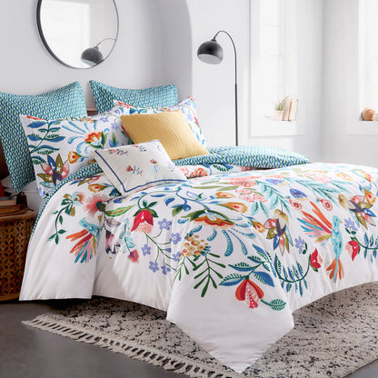 Colorful floral bedding set on a bed in a bright bedroom.