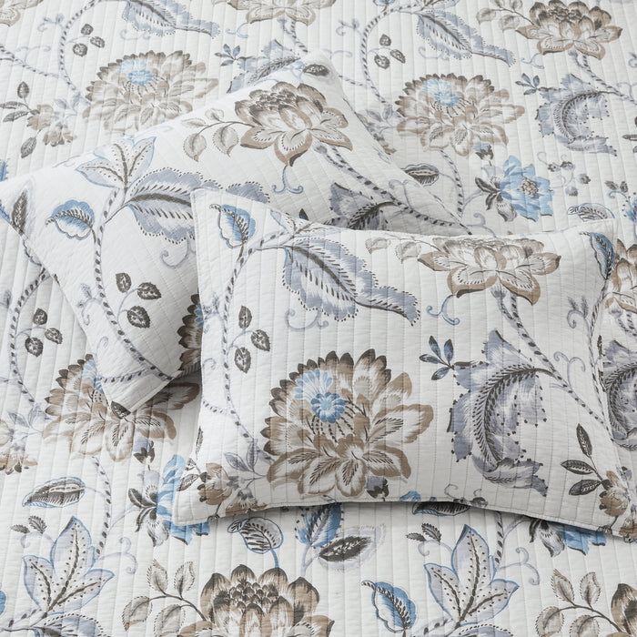 Floral patterned bedding set with pillows on a matching fabric background