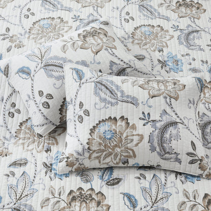Floral patterned bedding set with pillows on a matching fabric background