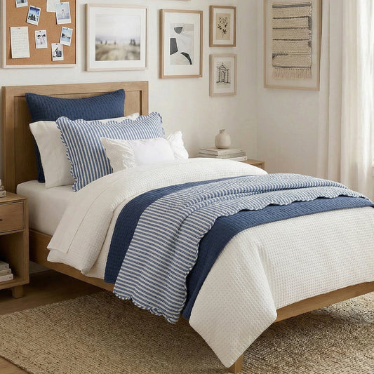 Bedroom with wooden bed, blue and white bedding, and framed pictures on the wall.