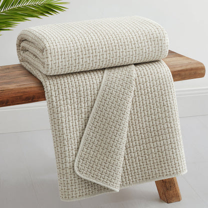 Pick-Stitch Artisan Quilted Throw draped over a wooden bench, featuring textured quilted cotton slub fabric.