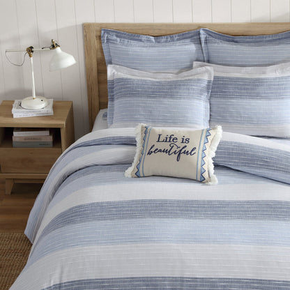 Coastal-style blue and white striped queen comforter set with decorative pillow on wooden bed frame