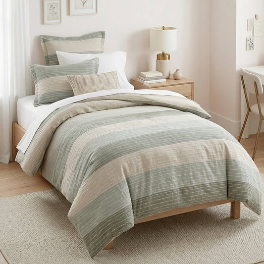 Bedroom with striped bedding and a lamp on a nightstand.