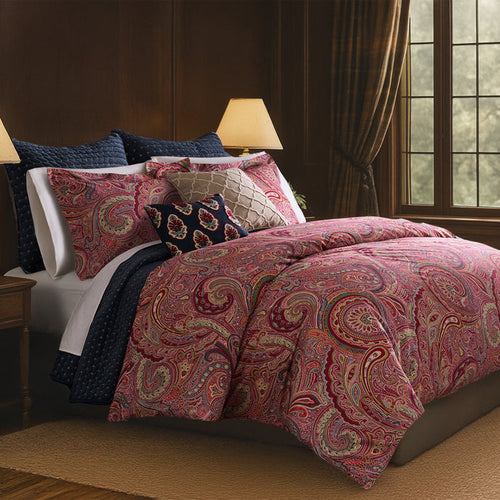 Spruce Comforter Set featuring a red and gold paisley print on a bed with navy and white pillows, perfect for stylish home decor.