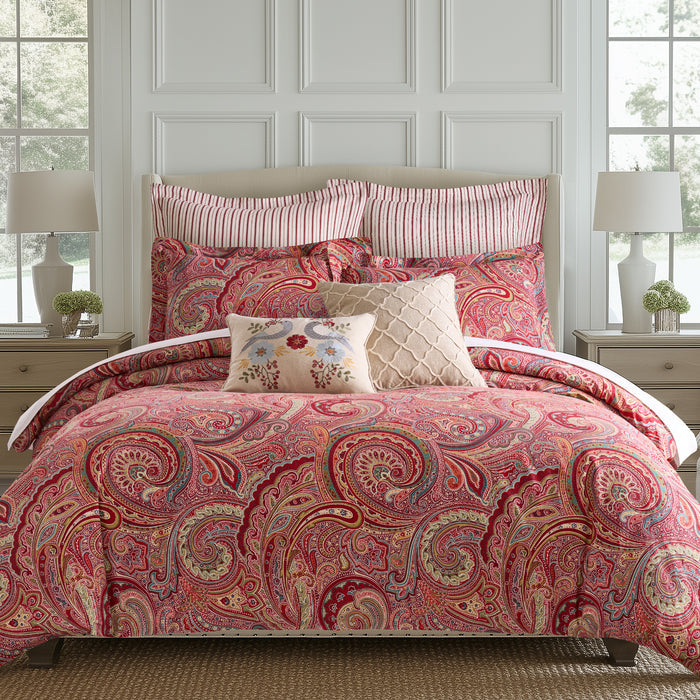 Spruce Comforter Set featuring a vibrant paisley print in red and gold, paired with decorative pillows.